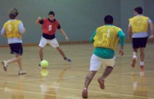 Teen Boys Passing Soccer Ball in Gym